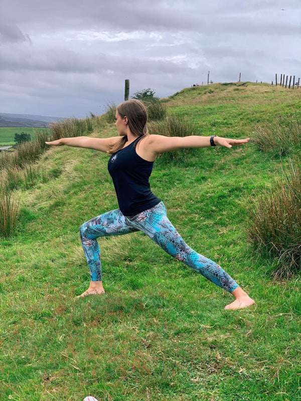 Lady Practising Warrior 2 Pose In The Welsh Hills
